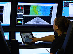 Colleen Peters attending the systems in the sonar control room on the R/V Falkor.