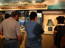 Visitors take a look at the ship's bell from the USS Saginaw.