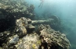 Maritime archaeologists float above one of two large paddle wheel shafts and hub beneath the surf zone.