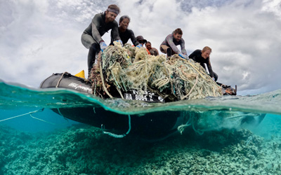 Divers work to remove a large derelict fishing net.