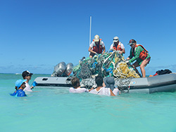 The Marine Debris Team loads a small boat with derelict fishing gear at Lisianski Island. 