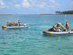 Workers transporting marine debris collected from the reefs to basecamp.