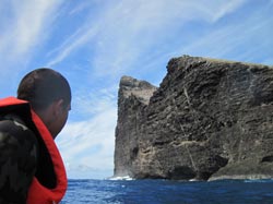 Researcher Patrick Springer evaluates the water conditions below the sheer cliffs of Nihoa Island.