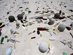 Beach in the remote Northwestern Hawaiian Islands strewn with debris washed ashore from afar.