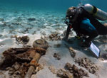 Maritime archaeologist Dr. Kelly Gleason investigates the distinctive landing gear of a wrecked Brewster F2A-3 Buffalo at Midway Atoll.