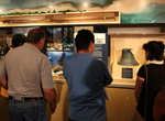 Visitors take a look at the ship's bell from the USS Saginaw, lost at Kure Atoll in 1870 and recovered by maritime archaeologists in 2008.