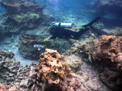 Kelly Gleason examines one of four trypots at the Two Brothers shipwreck site.