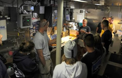 Maritime archaeologists discuss artifact recovery with scientists and crew on the Hi'ialakai.