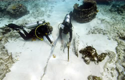 Kelly Gleason and Hans Van Tilburg document timbers hidden beneath the sand at the Pearl shipwreck site.
