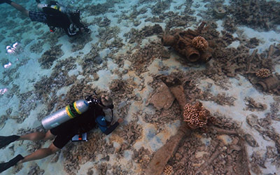 NOAA maritime archaeologists survey the remains of a sunken World War II era aircraft at Midway Atoll. Credit: NOAA/PMNM