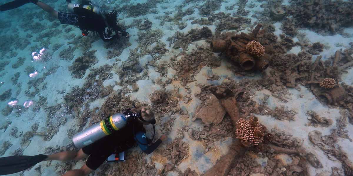 NOAA maritime archaeologists survey the remains of a sunken World War II era aircraft at Midway Atoll.