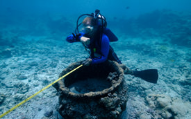 Maritime archaeologist Jason Raupp surveys a trypot at the <i>Two Brothers</i> site.