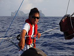 Crewmember Kaʻohinani Kamalu handles the head sail as the waʻa nears Nihoa.