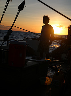 The sun sets behind watch captain Russell Amimoto.