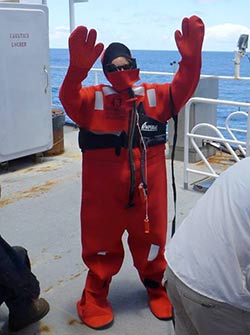 A member of the science party tries on the survival suit during an abandon ship drill.