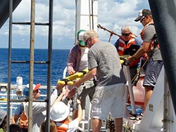 Crew and scientists practice transporting an ‘injured diver’ from the boat to the dive chamber.
