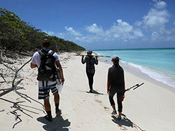 Maritime Heritage field team members survey the beach on Lisianksi Island.